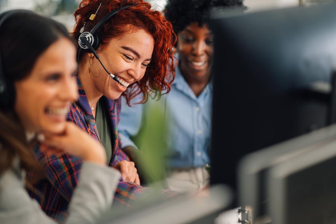 A group of telecoms workers smiling at a screen